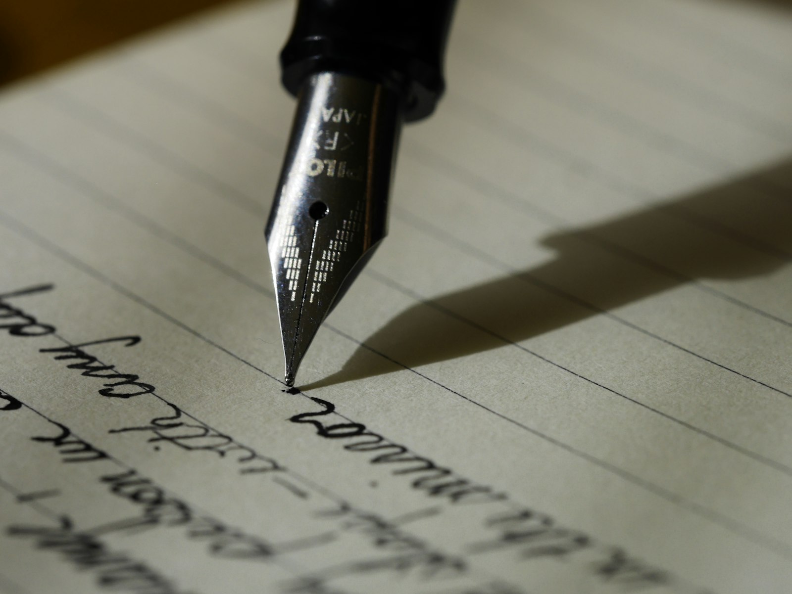 Fountain pen writing in a lined notebook, symbolising a consistent blogging habit over perfect design